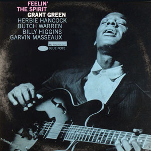 faded blue duotone image of grant green playing the guitar